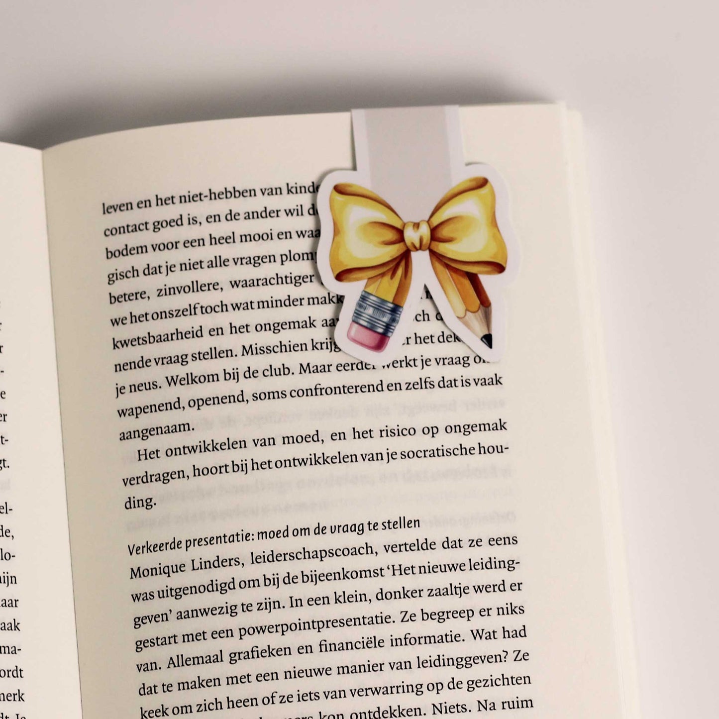 Magnetische boekenlegger vastgeklikt over een pagina van een open boek als bladwijzer