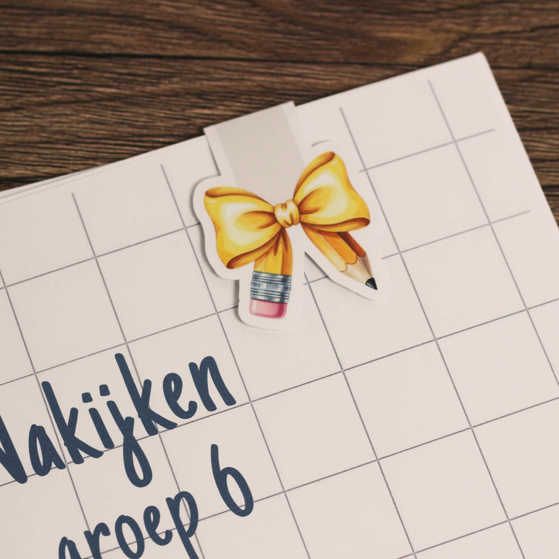 Magnetische boekenlegger bevestigd aan een schrift met ruitjespagina als voorbeeld van gebruik