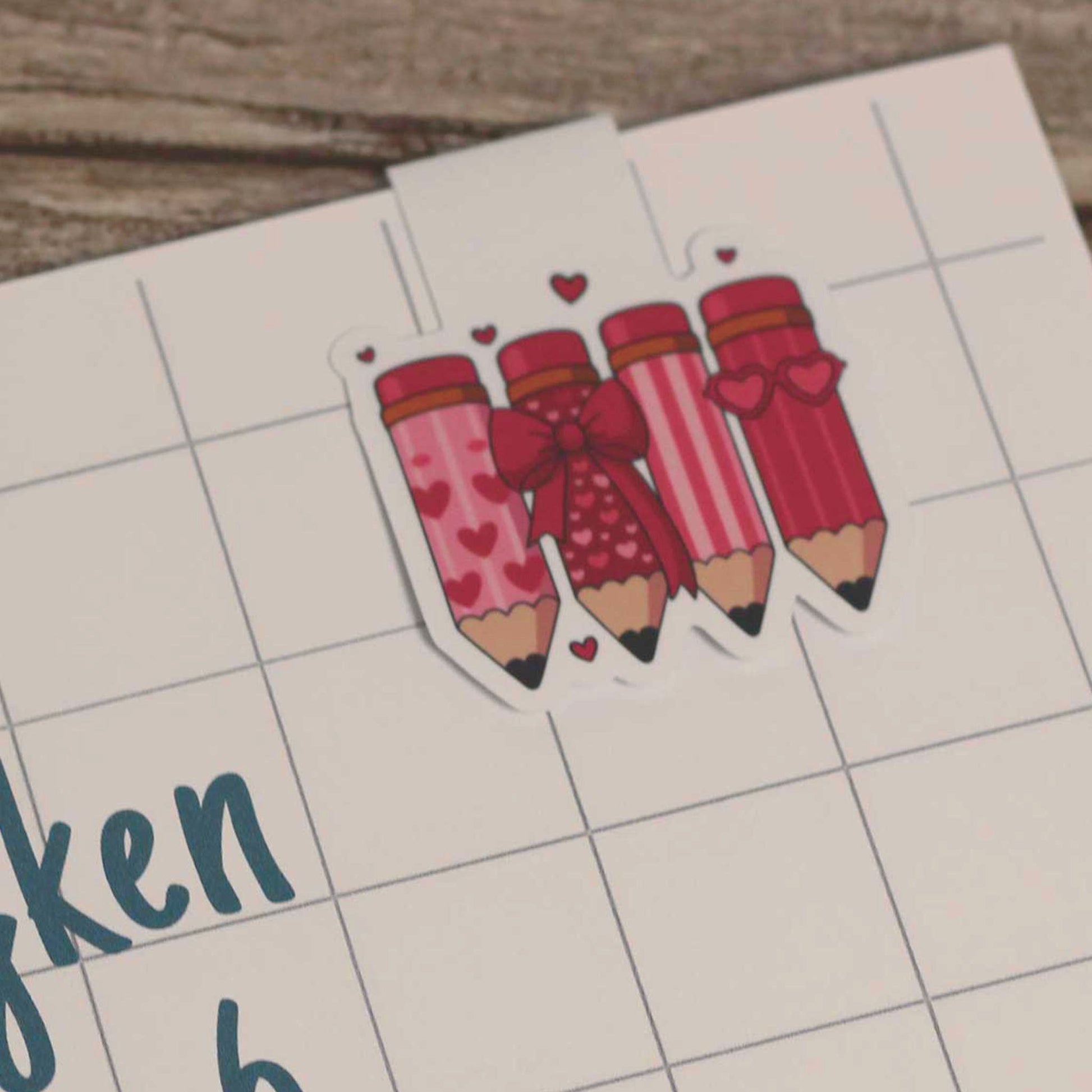 Magnetische boekenlegger bevestigd aan een schrift met ruitjespagina als voorbeeld van gebruik