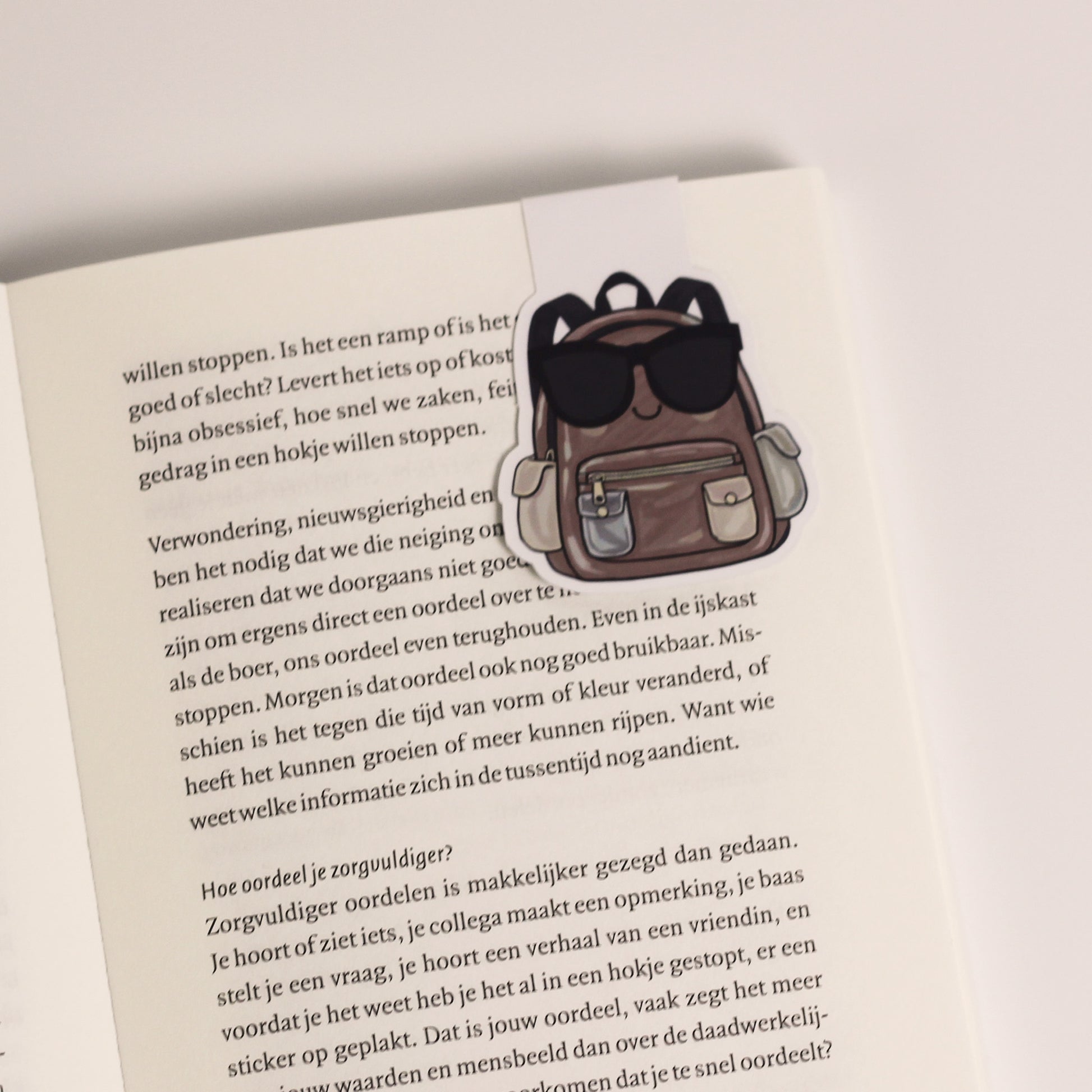 Magnetische boekenlegger vastgeklikt over een pagina van een open boek als bladwijzer