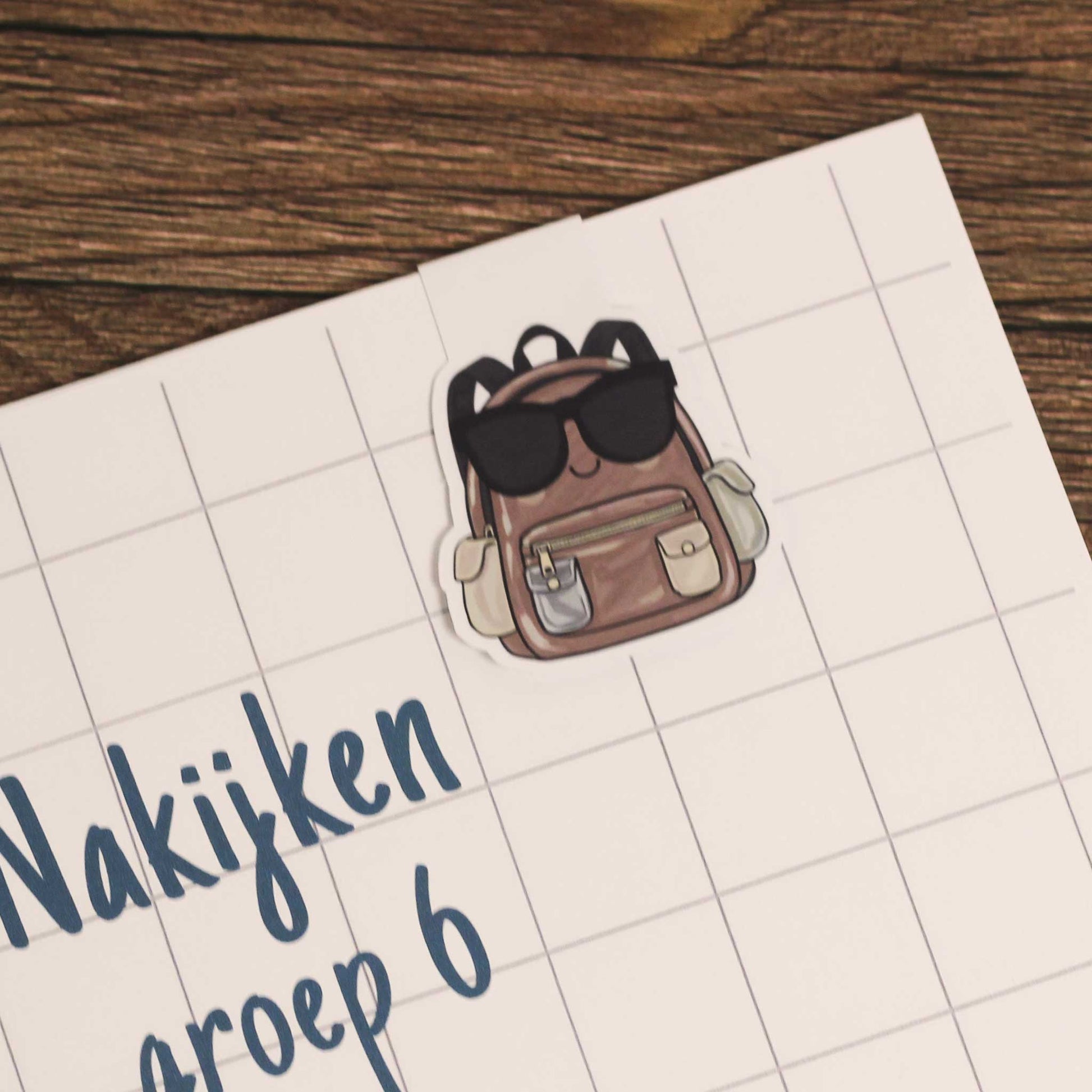 Magnetische boekenlegger bevestigd aan een schrift met ruitjespagina als voorbeeld van gebruik