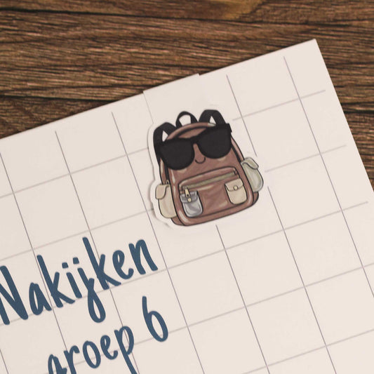 Magnetische boekenlegger bevestigd aan een schrift met ruitjespagina als voorbeeld van gebruik