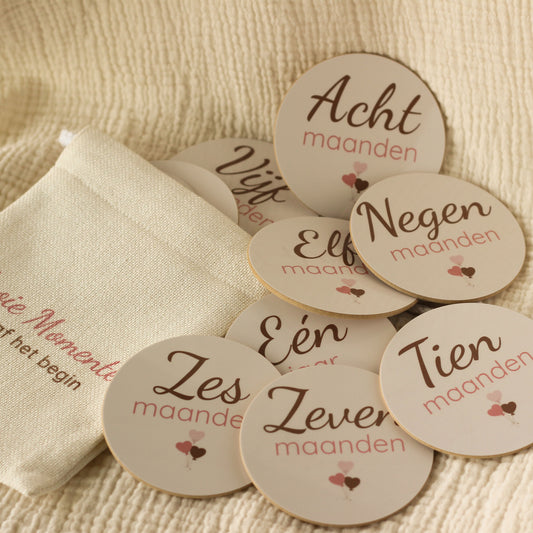 Baby mijlpaalschijfjes set met linnen cadeauzakje op beige ondergrond