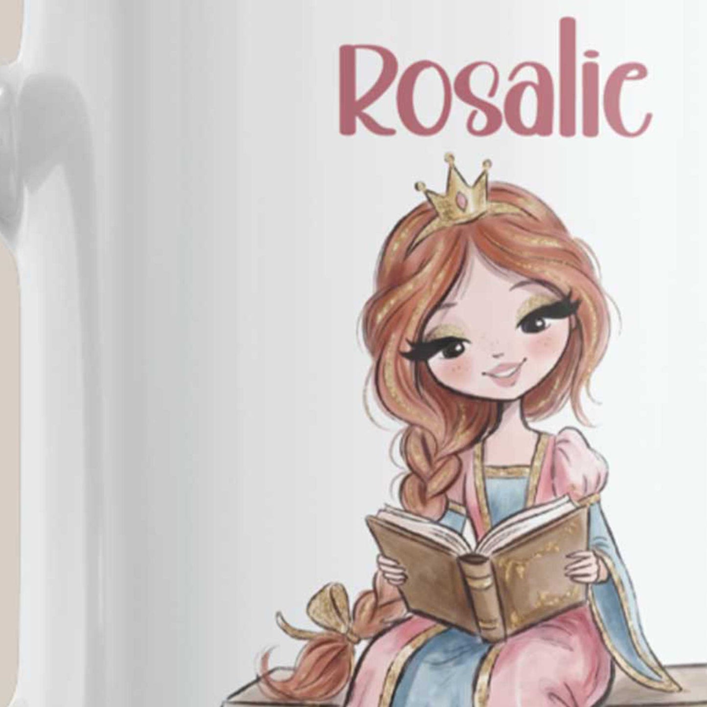 Close-up van een witte mok met de naam Rosalie en een prinses met kroon die op een bankje zit en een open boek leest.