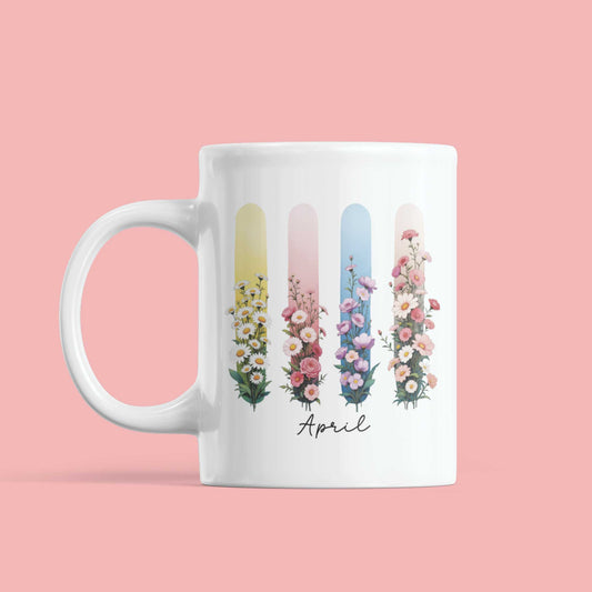 Witte mok met kleurrijke geboortebloemen van april (madeliefje & lathyrus) op gekleurde brushstrepen – lenteachtig en zacht ontwerp.