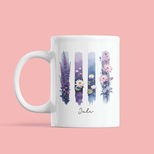 Witte mok tegen roze achtergrond met paarse en blauwe brushstroken en illustraties van geboortebloemen van juli – elegant en rustgevend design.