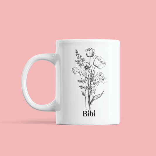 gepersonaliseerde witte mok met een zwarte schets van bloemen en een naam in zwart