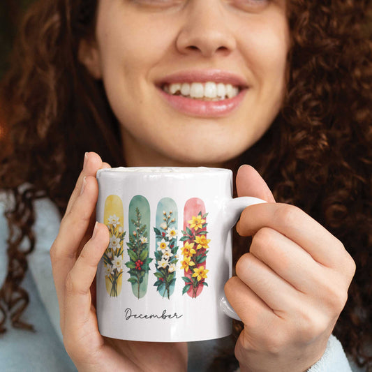 Vrouw met krullen houdt een mok vast met decemberbloemen narcis en hulst op kleurrijke brushstroken, tekst ‘December’ zichtbaar.