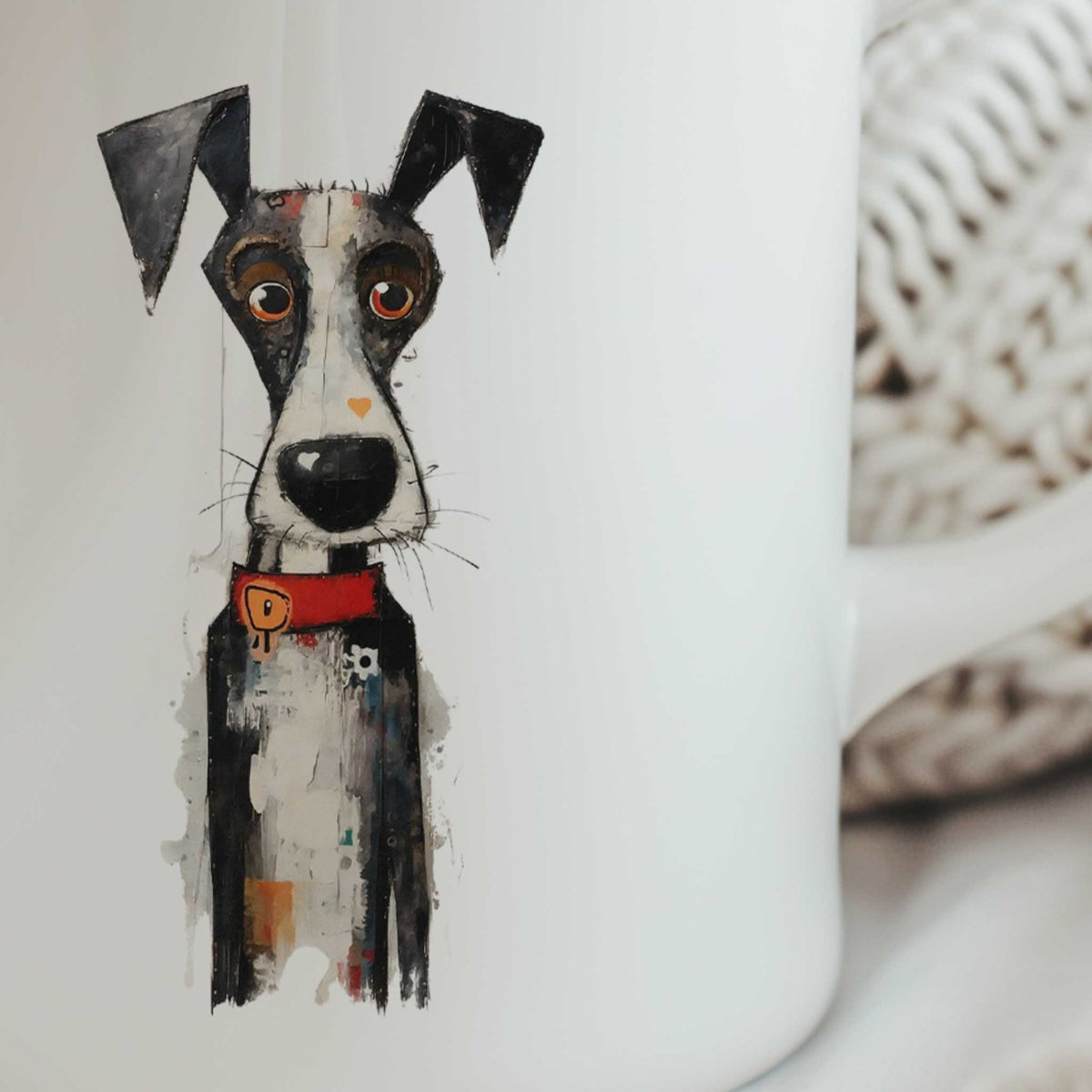 Close-up van een zwart-witte artistieke hond op een witte mok, met grote zwarte oren, oranje ogen, zwarte snoet en rode halsband.