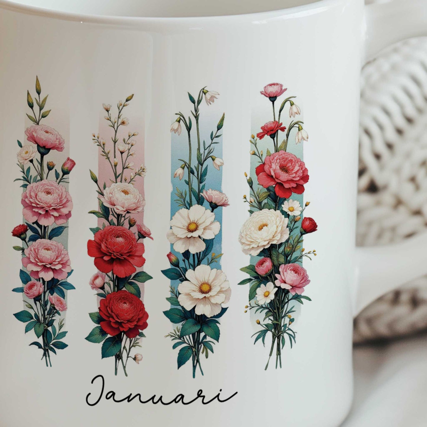 Close-up van de witte mok met de geboortebloem van januari in brush effect, waarop de bloemenillustratie en de tekst 'Januari' duidelijk zichtbaar zijn.