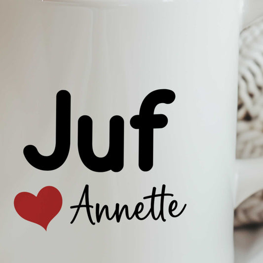 Close-up van een witte mok met de tekst Juf, een rood hartje en de naam Annette