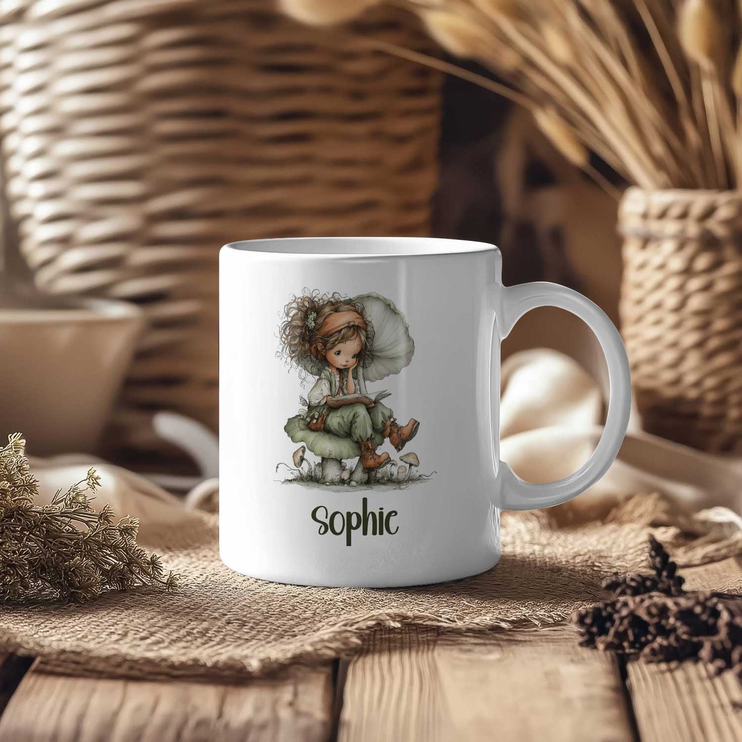 Witte mok met een leesfee op een paddenstoel en de naam Sophie op een houten tafel met manden en droogbloemen op de achtergrond.