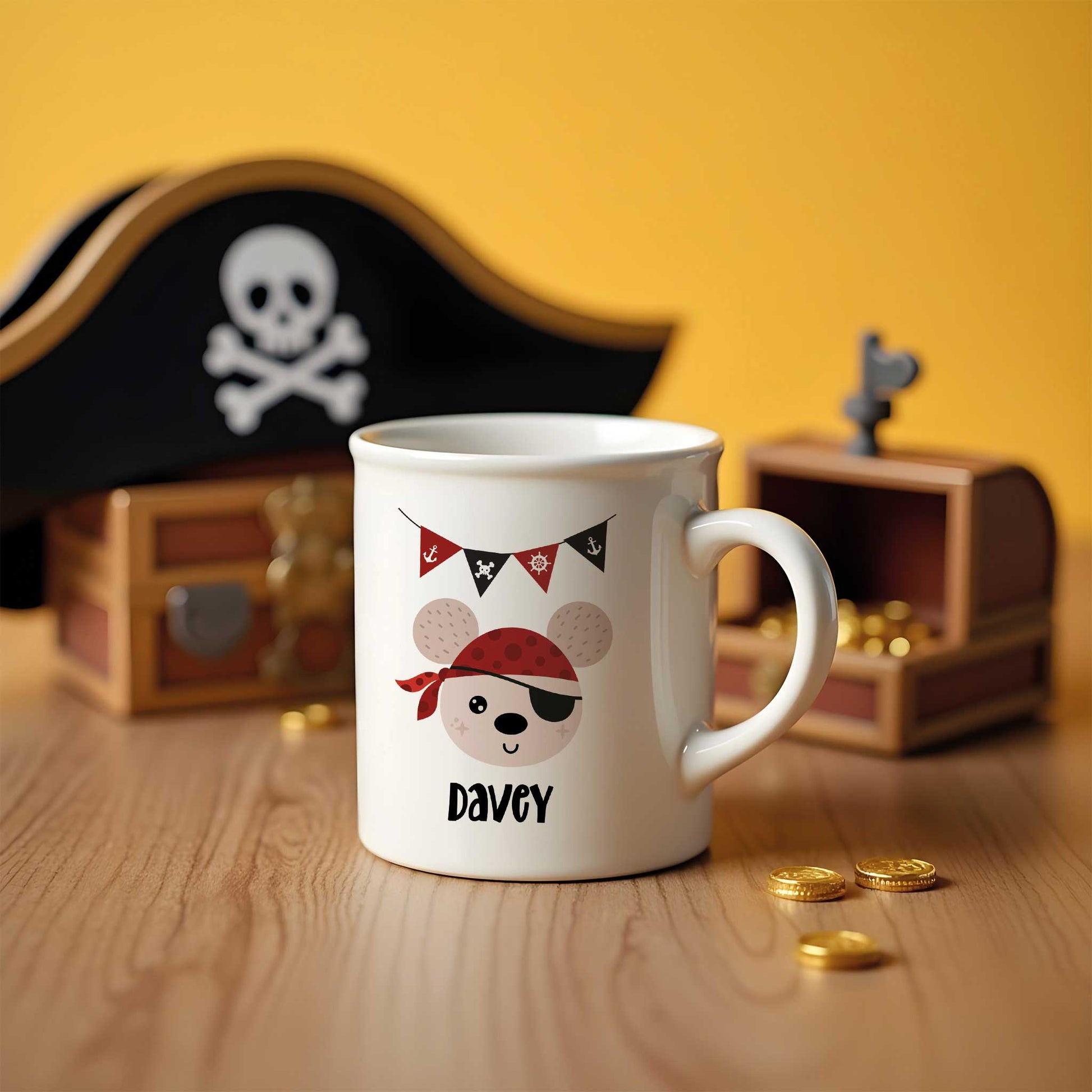 Witte mok met piratenbeer design en vlaggetjes, geplaatst naast speelgoed schatkist met gouden munten