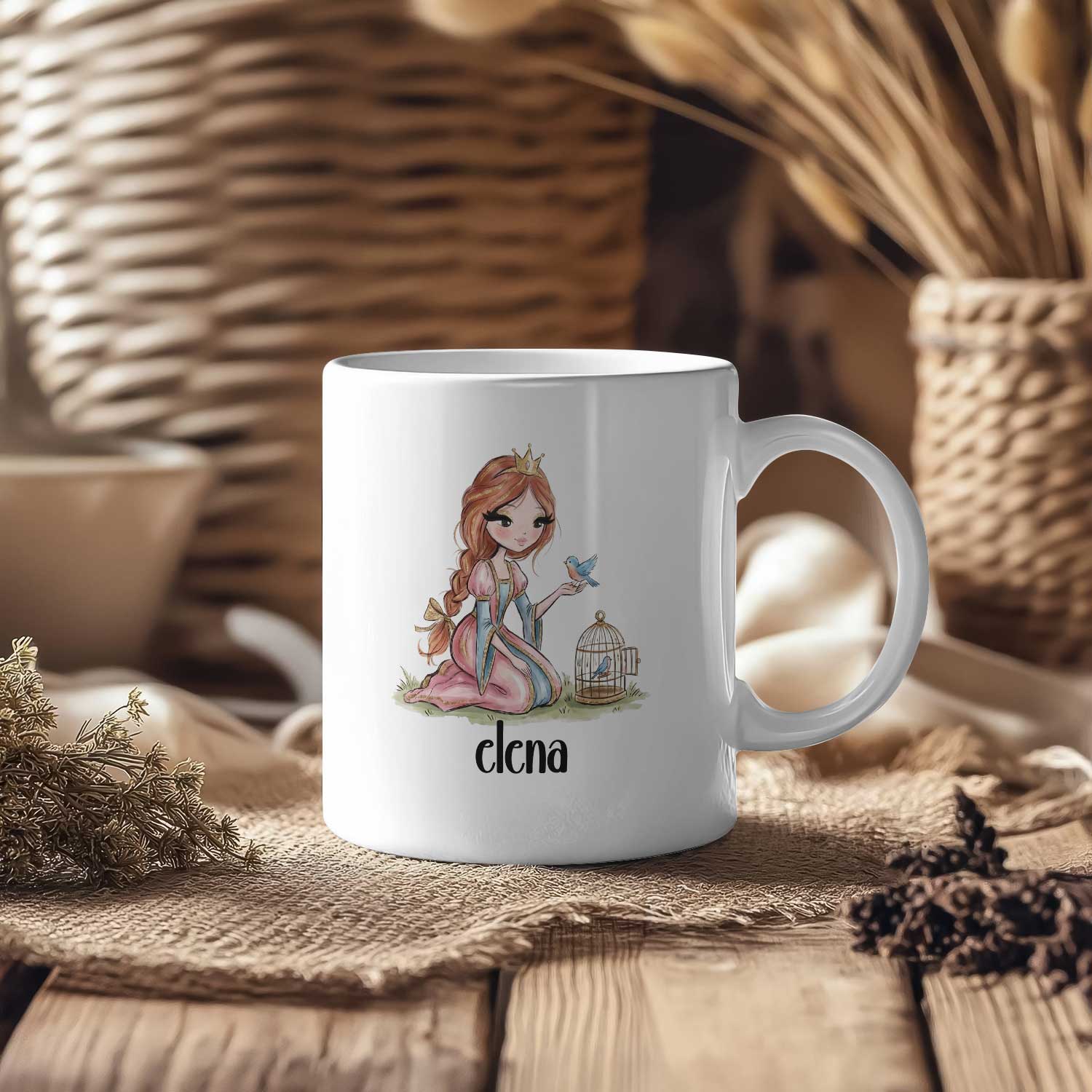 Witte mok met een prinses, een blauw vogeltje en de naam Elena op een houten tafel met manden en gedroogde takken op de achtergrond.