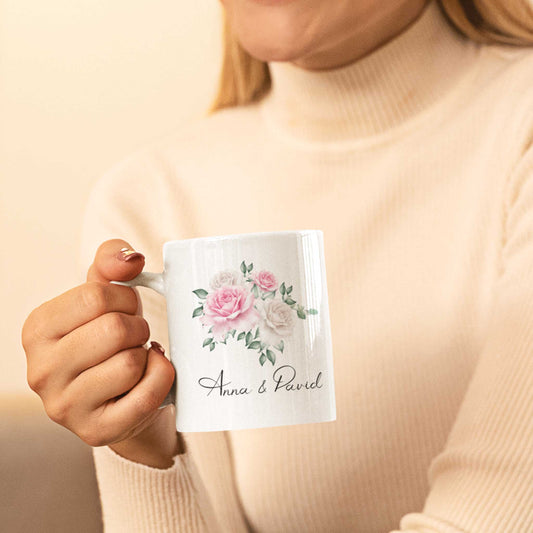 Vrouw houdt gepersonaliseerde mok vast met namen van bruidspaar en romantische rozenillustratie – ideaal als huwelijkscadeau
