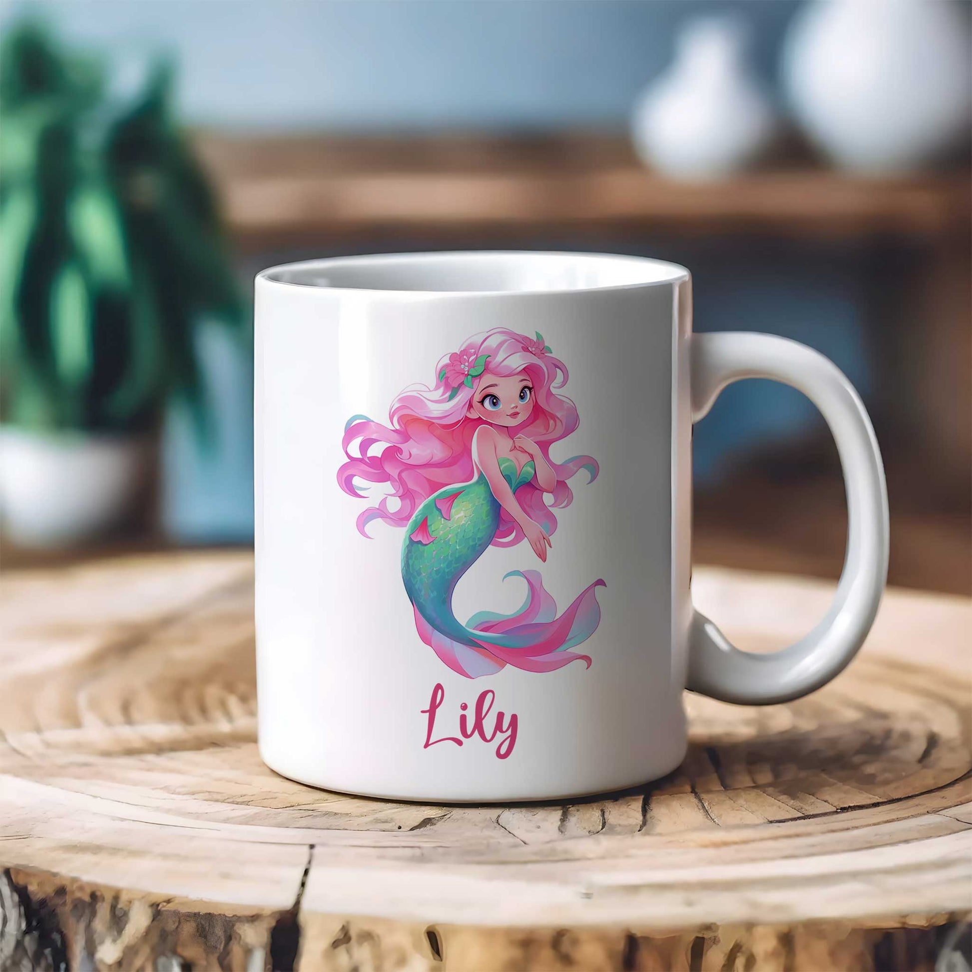 Witte keramische mok op een houten tafel met een illustratie van een zeemeermin met lang roze haar en bloemen in haar haar. De naam Lily staat onder de afbeelding in roze letters.