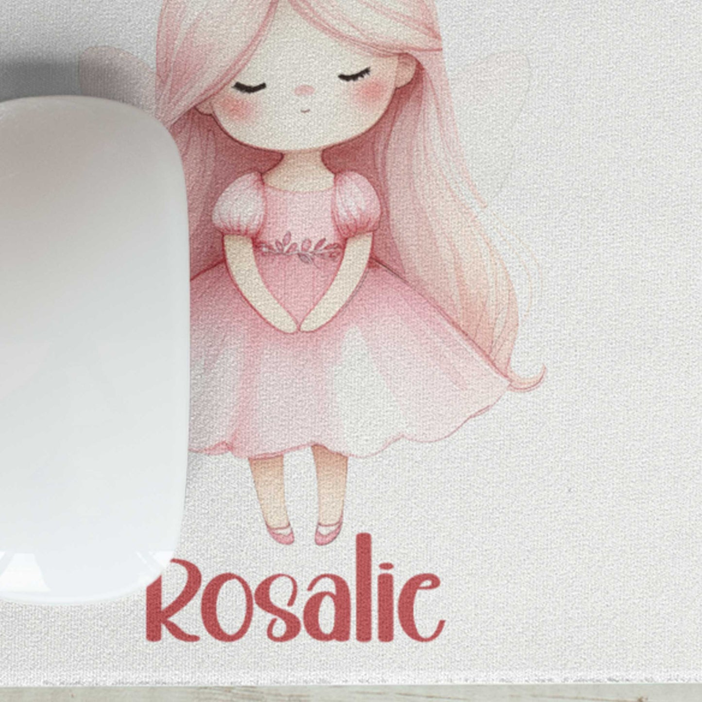 Close-up van een witte muismat met een schattige prinses met roze kroontje, lange roze haren en de naam Rosalie. Een witte computermuis ligt deels op de muismat.