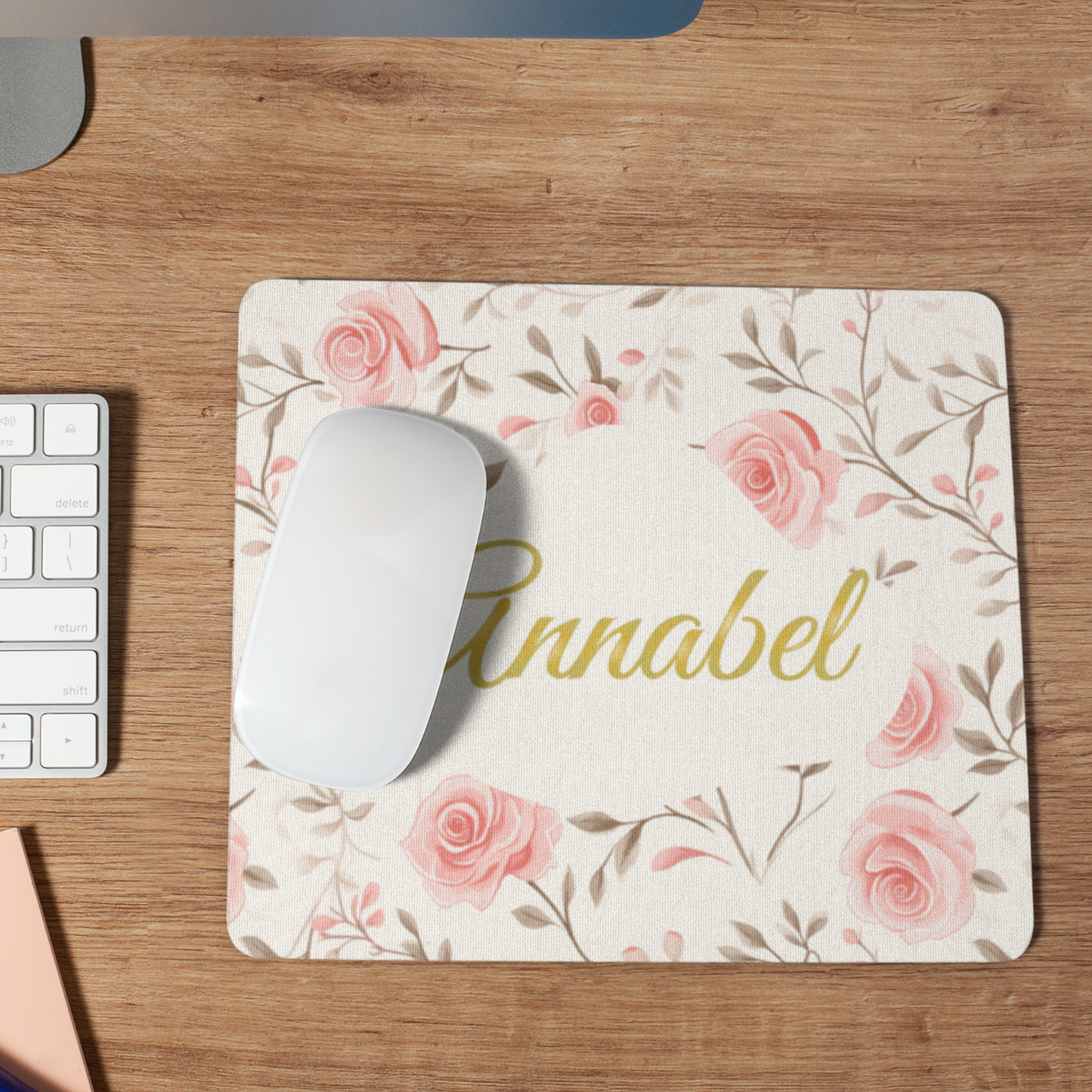 Muismat met roze rozen en een naam in sierlijk goud. De naam is aanpasbaar op een bureau met een witte muis erop 