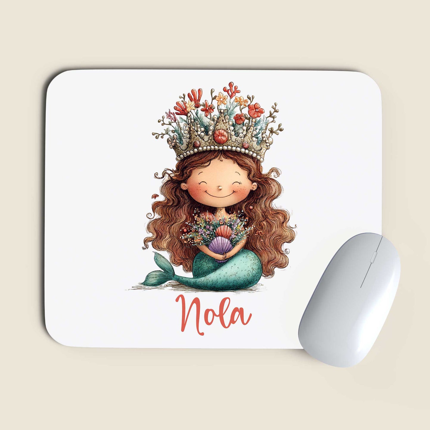Witte muismat met een zeemeermin met een kroon van koraal, schelpen en bloemen en de naam Nola naast een witte computermuis op een beige achtergrond.