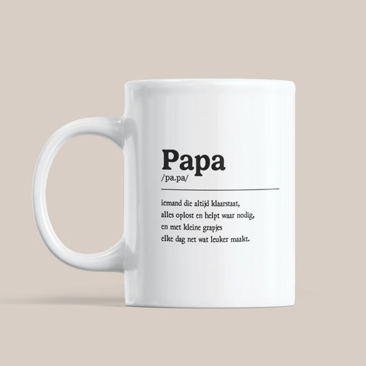Witte keramische mok met de tekst “Papa” en een betekenisvolle beschrijving op lichte beige achtergrond.