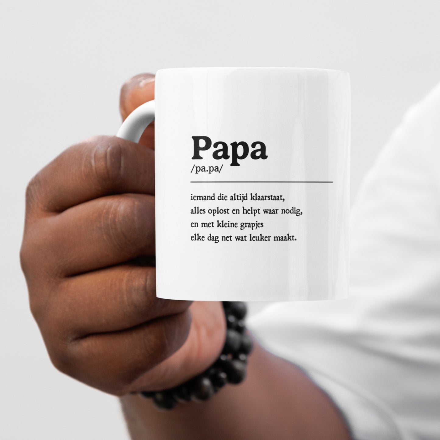 Witte papa mok met tekst wordt vastgehouden in een hand als lifestyle foto voor Vaderdag cadeau.