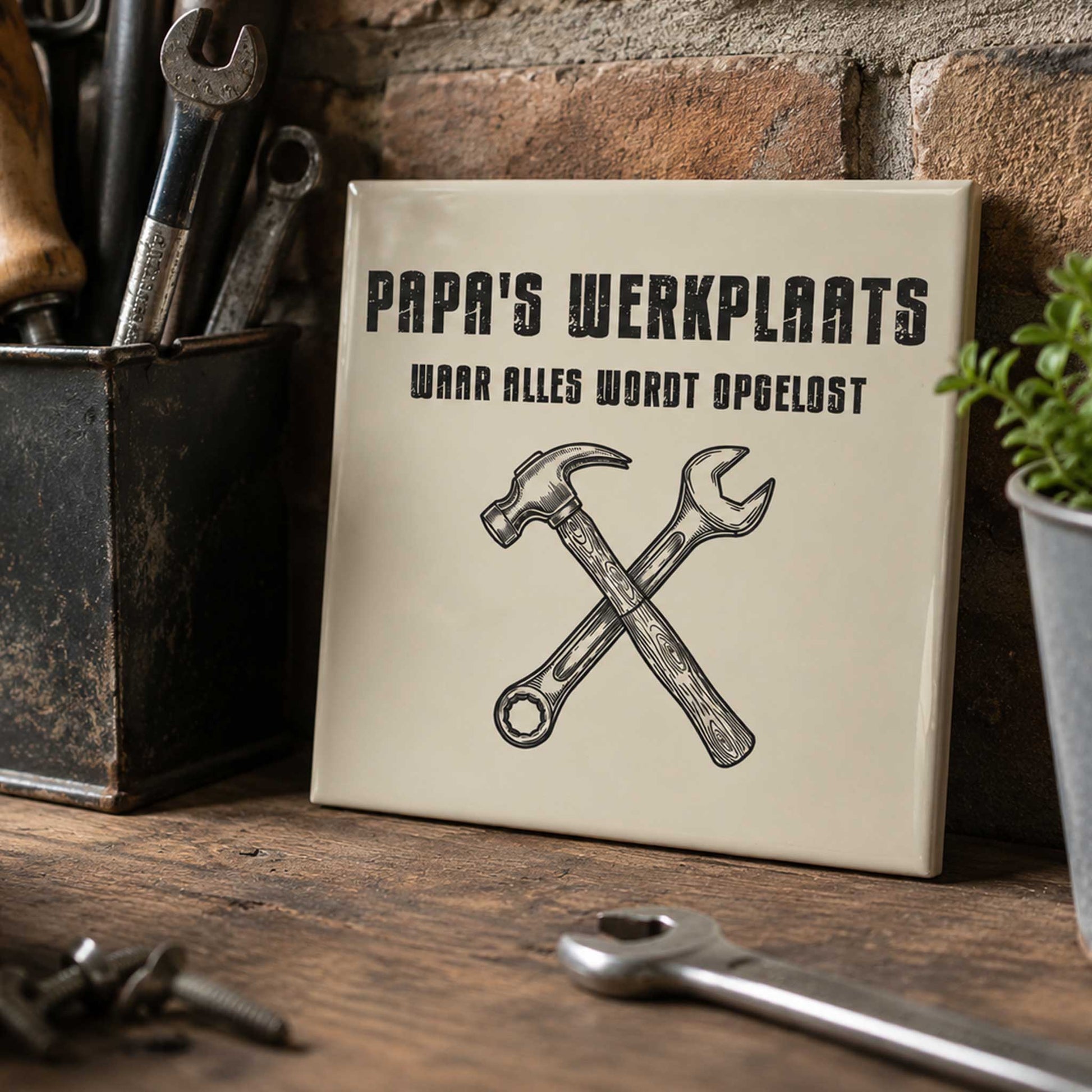 Keramisch tegeltje met de tekst “Papa’s Werkplaats Waar Alles Wordt Opgelost” en illustratie van een hamer en steeksleutel in een stoere werkplaats setting