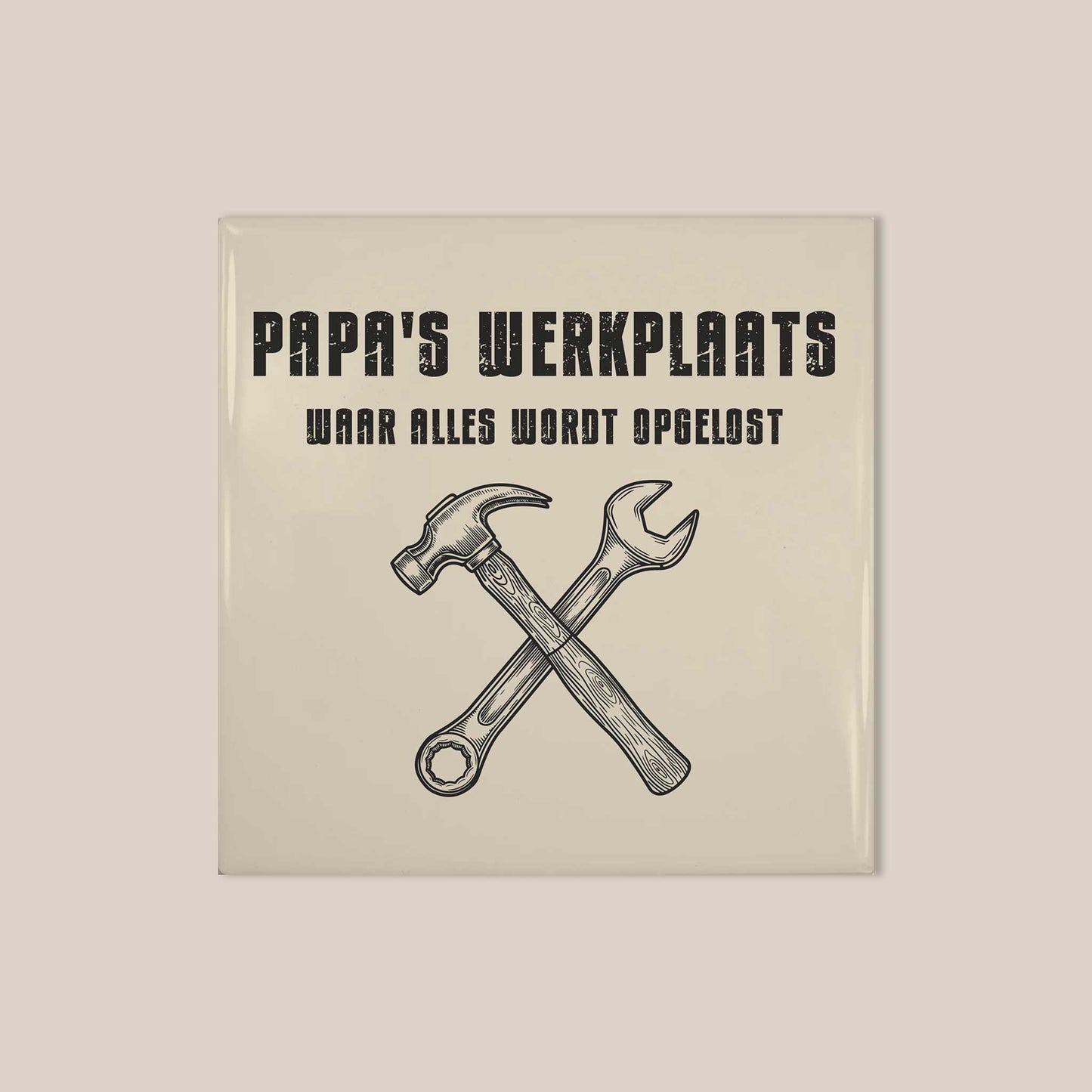 Vierkant keramisch tegeltje met zwarte vintage tekst “Papa’s Werkplaats” en gereedschap illustratie op een lichte achtergrond