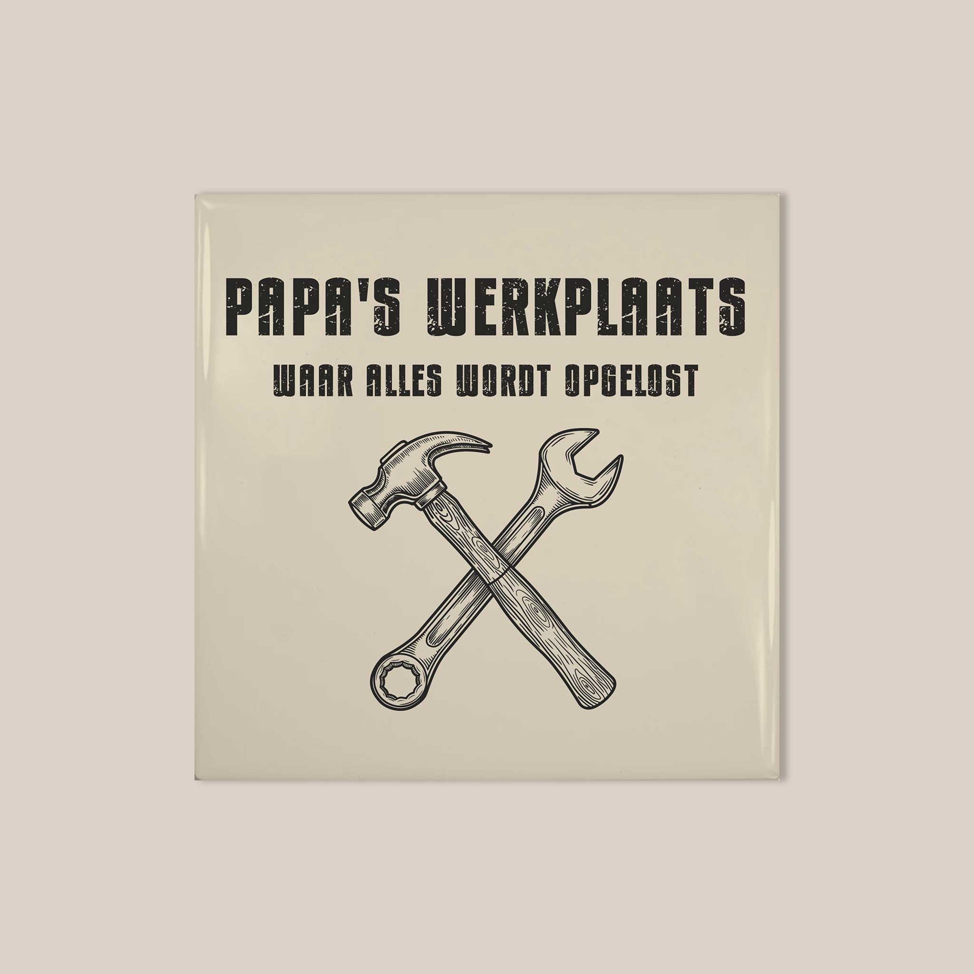 Vierkant keramisch tegeltje met zwarte vintage tekst “Papa’s Werkplaats” en gereedschap illustratie op een lichte achtergrond