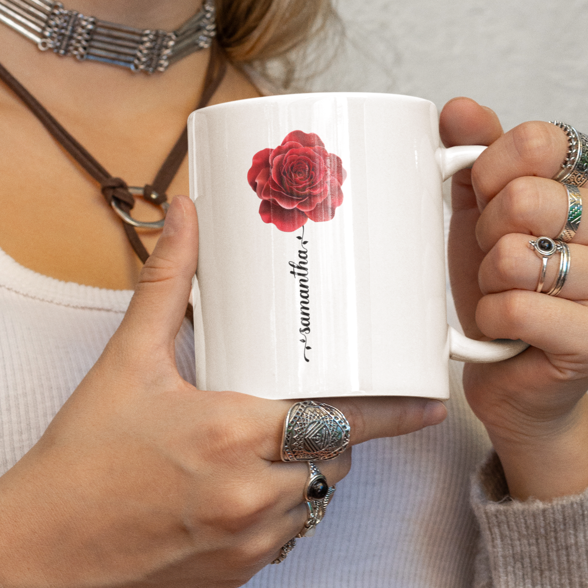 een vrouw die een mok met rode roos en naam die gepersonaliseerd kan worden   , in haar hand houd 