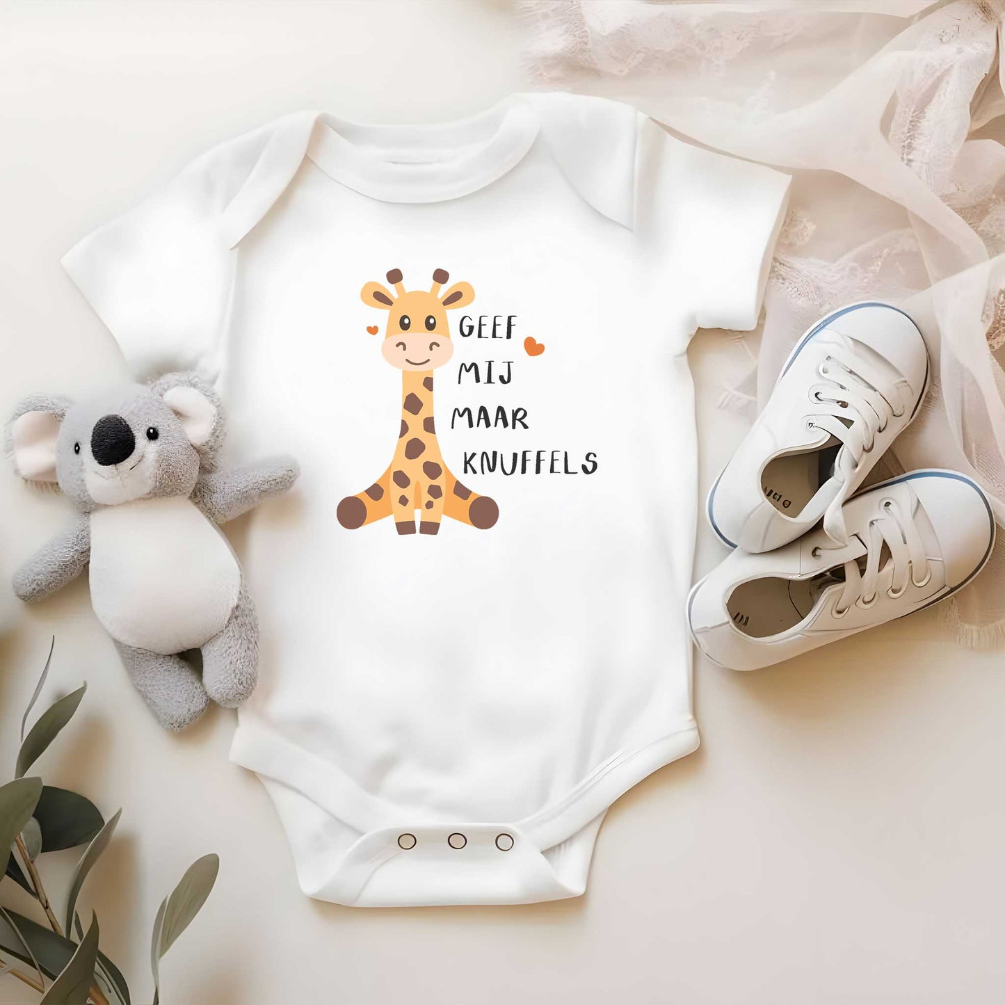 Witte romper met girafje en tekst in mandje met babyschoentjes