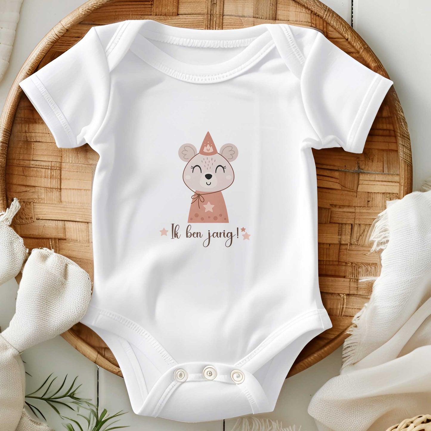 Wit rompertje met muis-illustratie en tekst "Ik ben jarig!" op een houten schaal met decoratie