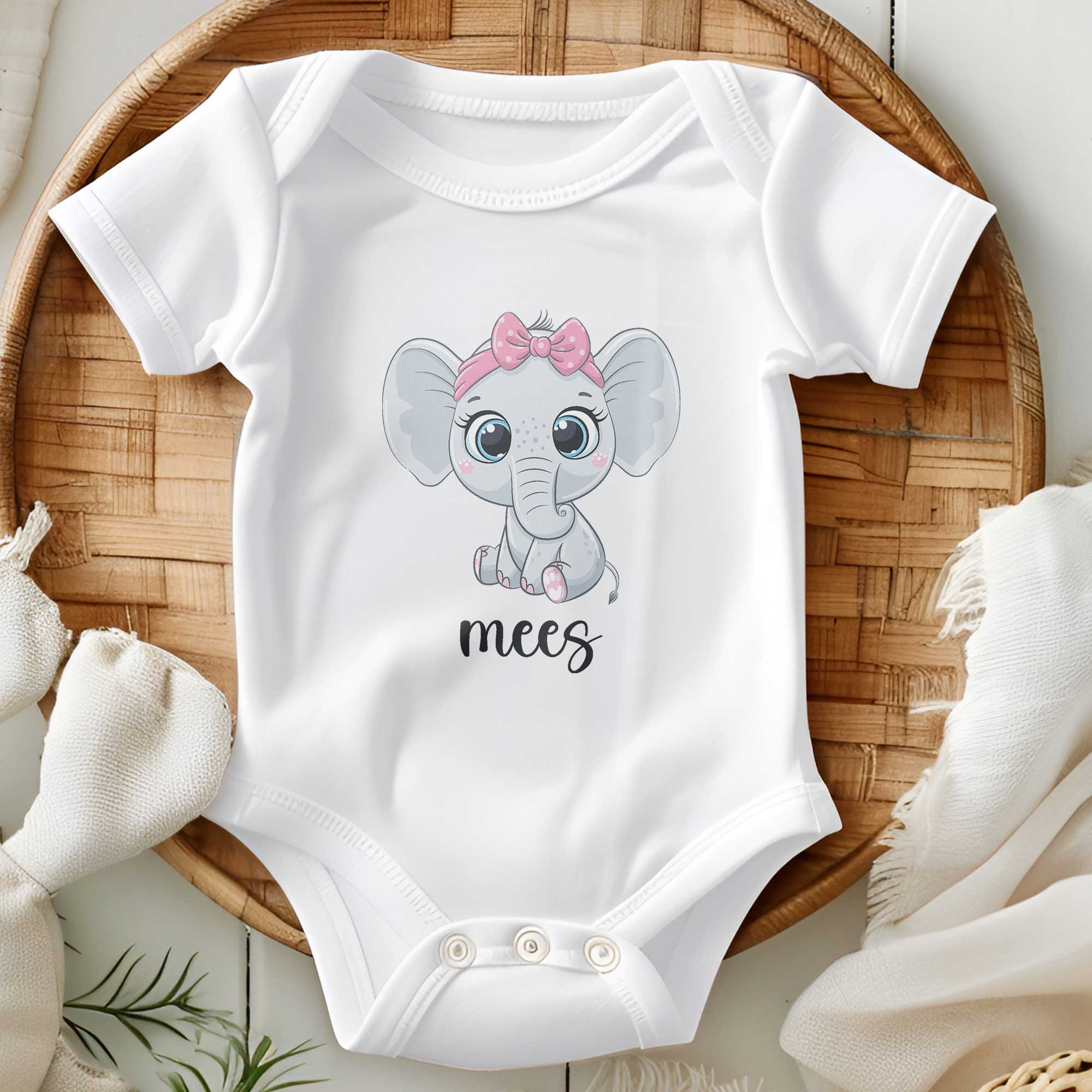 Wit babyrompertje met schattige illustratie van een olifantje met roze strik, opgevouwen in een rotan mand met neutrale aankleding, naam gedrukt in zwarte sierletters.