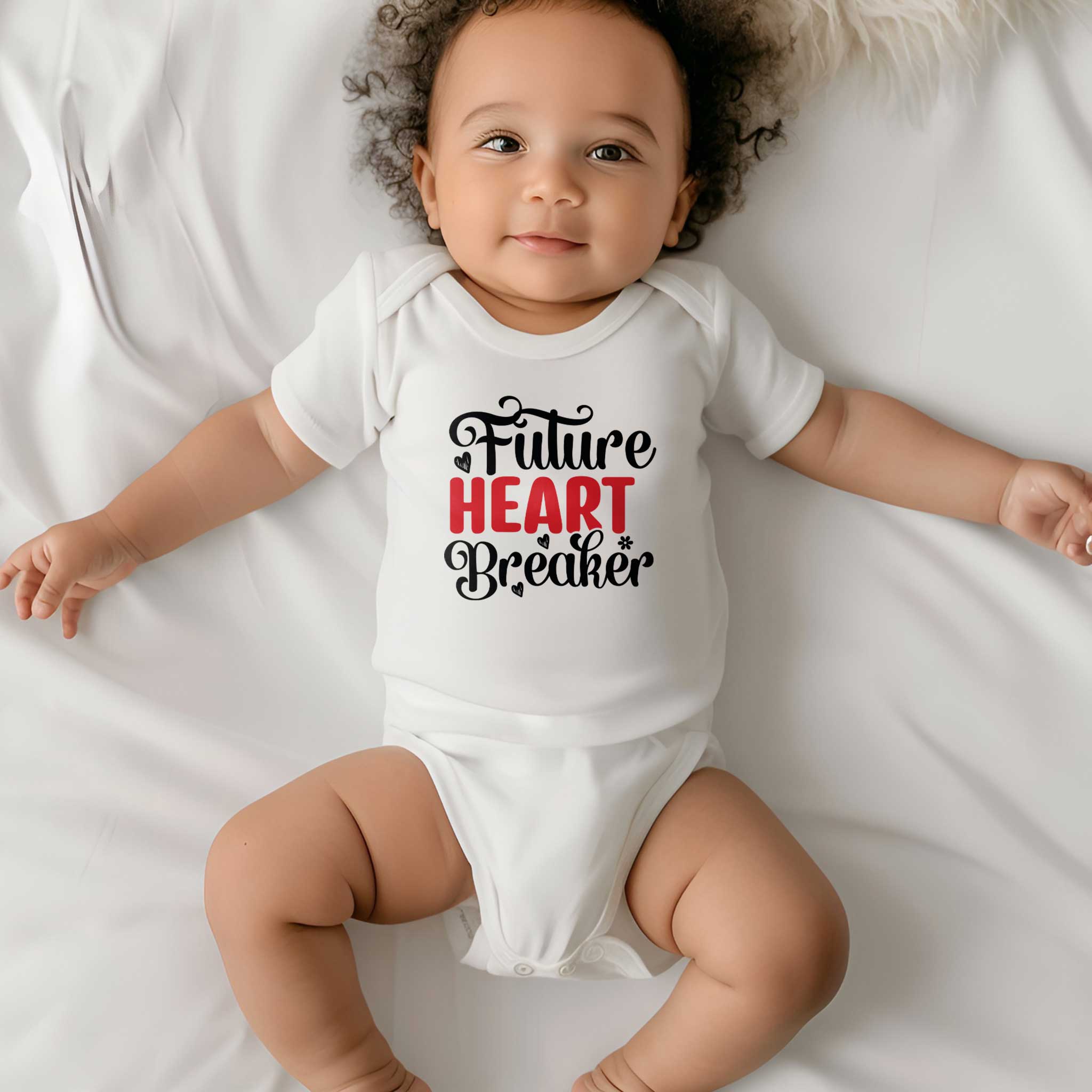 Baby ligt op een wit laken en draagt een wit rompertje met de tekst ‘Future Heart Breaker’.