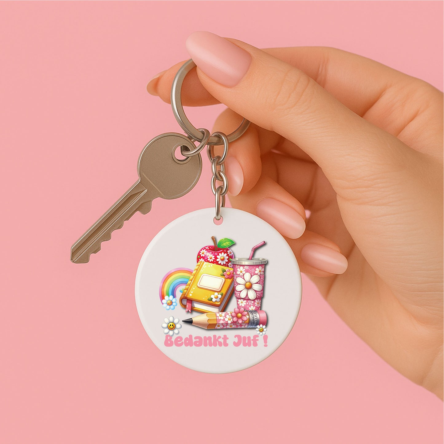 ronde sleutelhanger voor juf met de tekst bedankt juf in roze en groovy illustraties zoals een appel, boek, regenboog en beker met bloemen