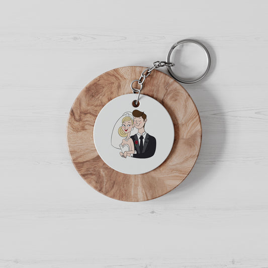 ronde witte sleutelhanger met een grappige cartoon van een bruidspaar op een rond stuk hout
