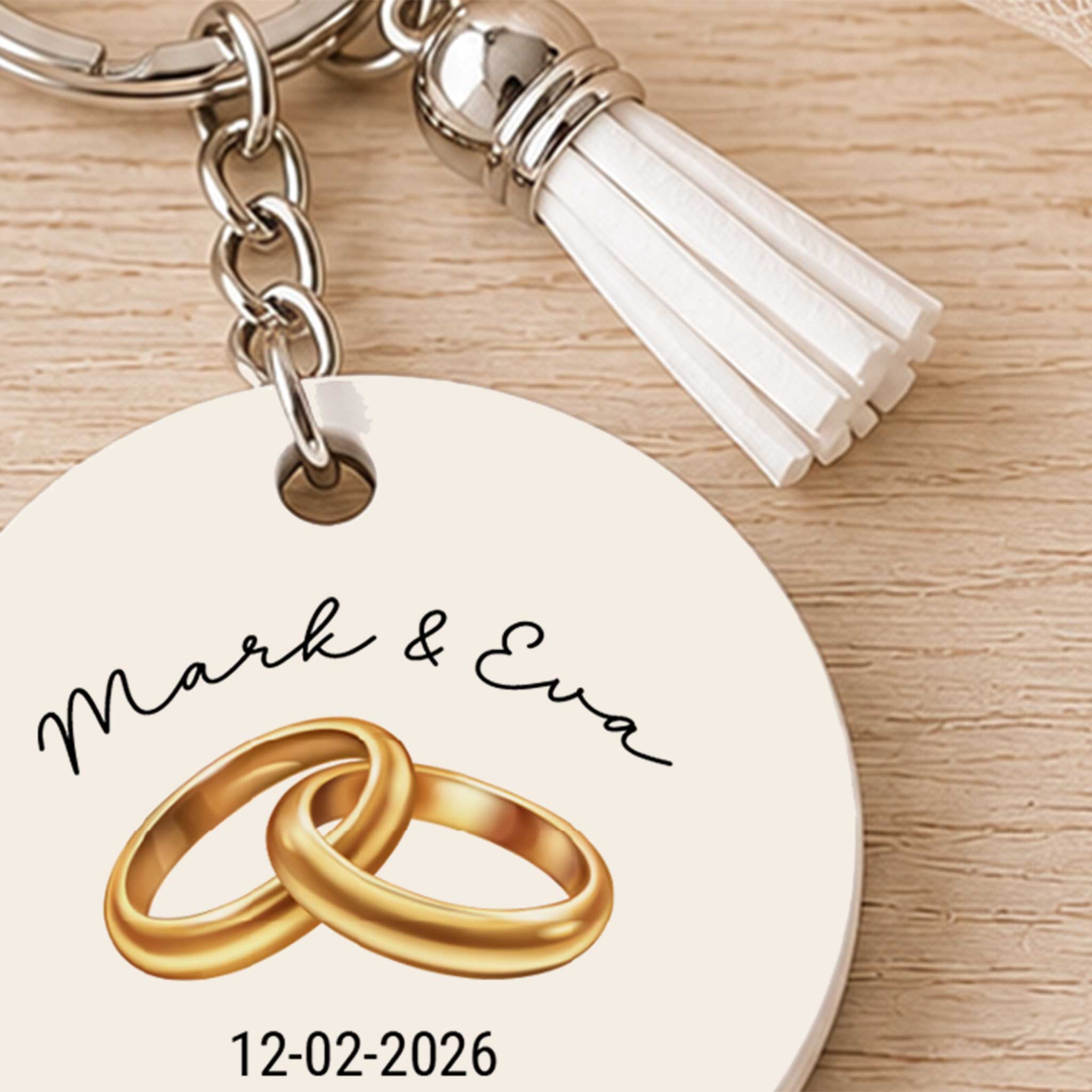 Close-up van gepersonaliseerde sleutelhanger met gouden trouwringen, namen en trouwdatum