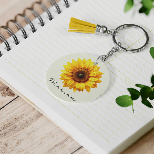 Gepersonaliseerde zonnebloem sleutelhanger met naam Marian, op notitieboek met geel kwastje