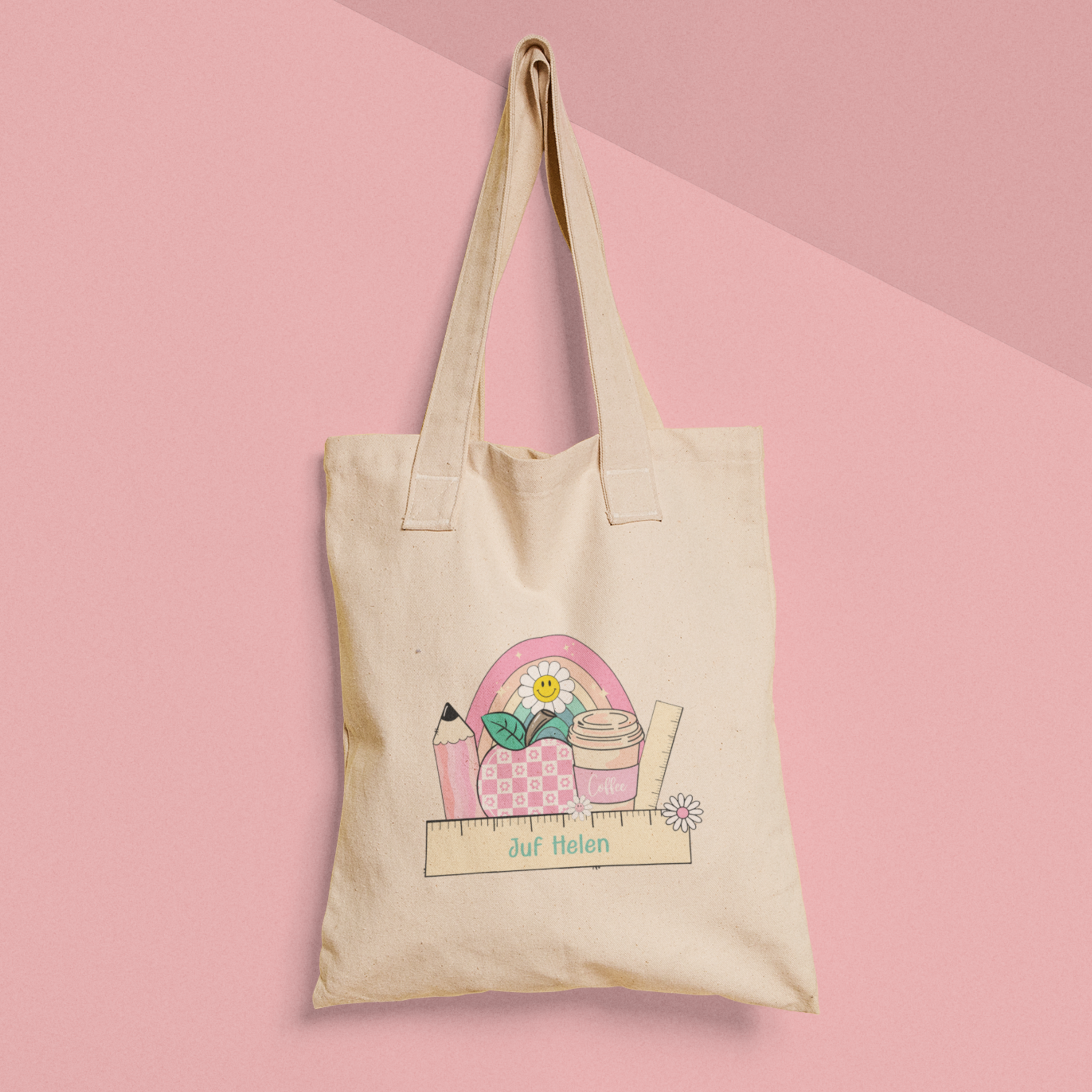 gepersonaliseerde tote bag voor juf met naam op lineaal met erachter illustraties  van rgenboog appel, potlood en beker in roze kleuren