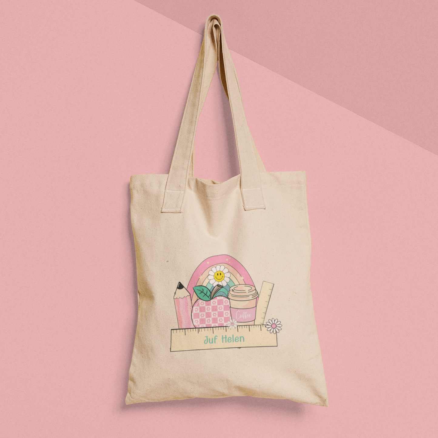 gepersonaliseerde tote bag voor juf met naam op lineaal met erachter illustraties  van rgenboog appel, potlood en beker in roze kleuren