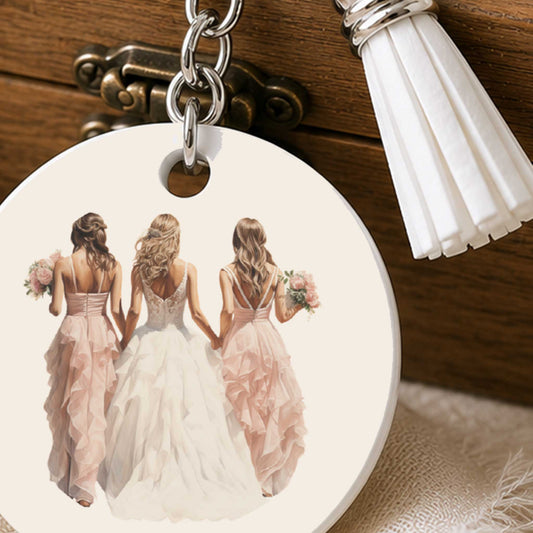 Close-up van sleutelhanger met bruid en bruidsmeisjes, zilverkleurige hardware en witte kwast