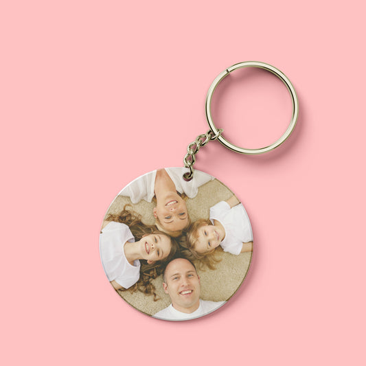 Ronde sleutelhanger met een persoonlijke familiefoto op roze achtergrond