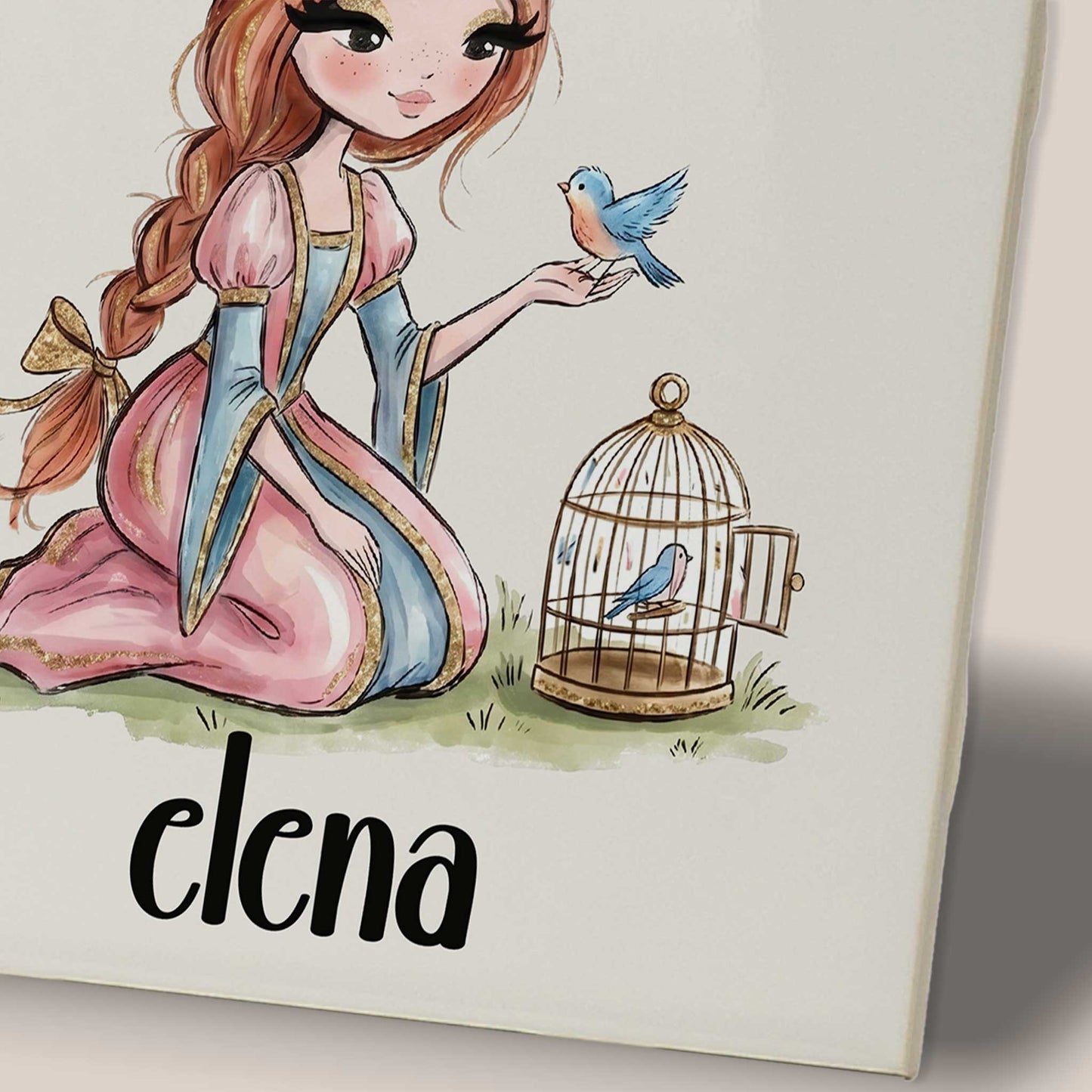 Close-up van een keramisch tegeltje met de prinses, een blauw vogeltje op haar hand, een open vogelkooitje en de naam Elena.