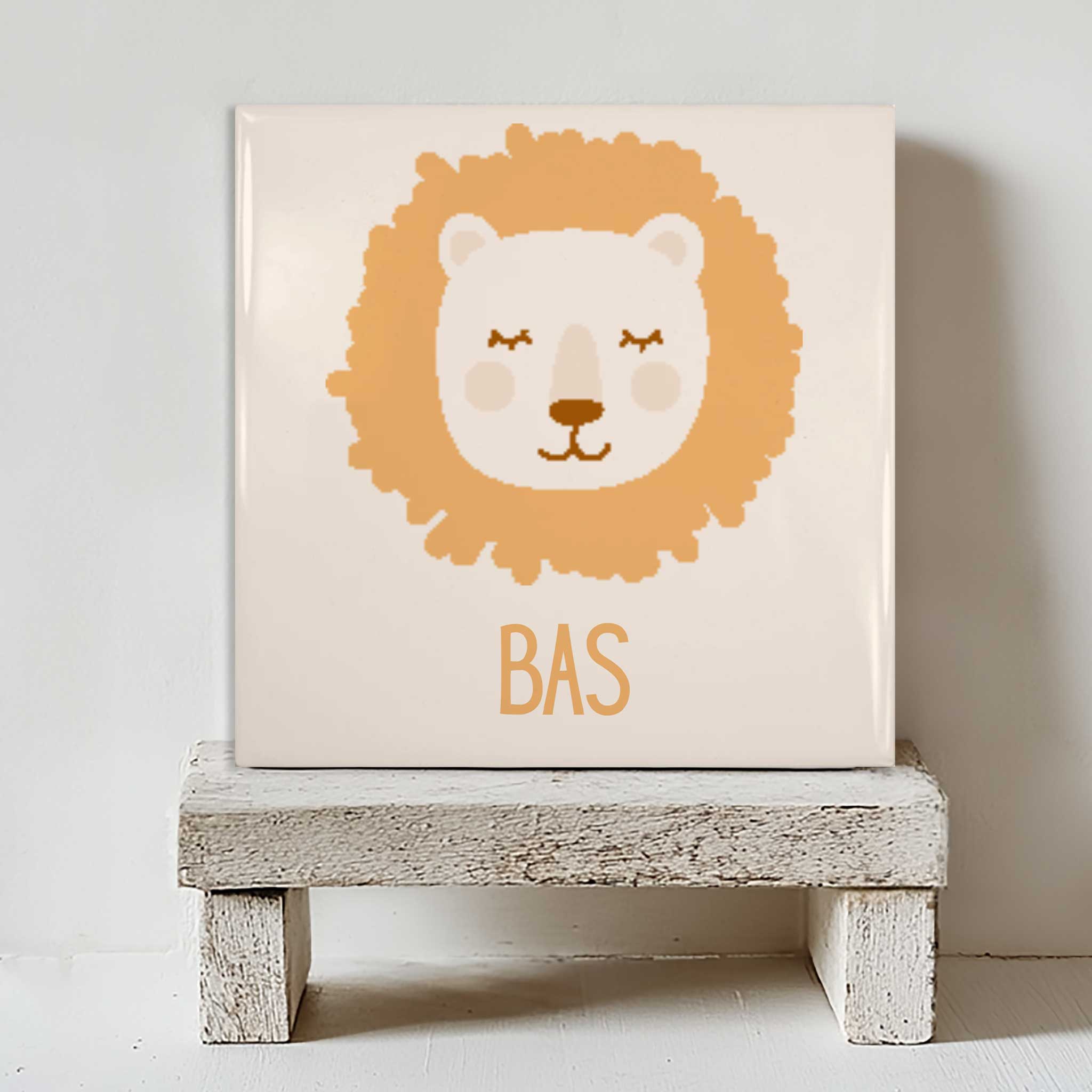 Wit keramisch tegeltje met leeuw en naam Bas, staand op een houten standaard