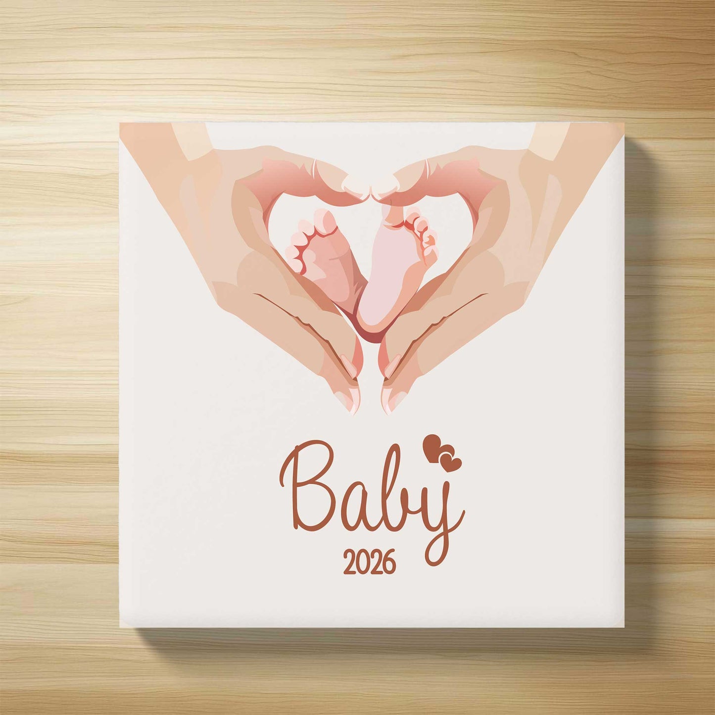 Bovenaanzicht van gepersonaliseerd babytegeltje met illustratie van babyvoetjes in hartvorm en de tekst Baby 2026 op houten ondergrond
