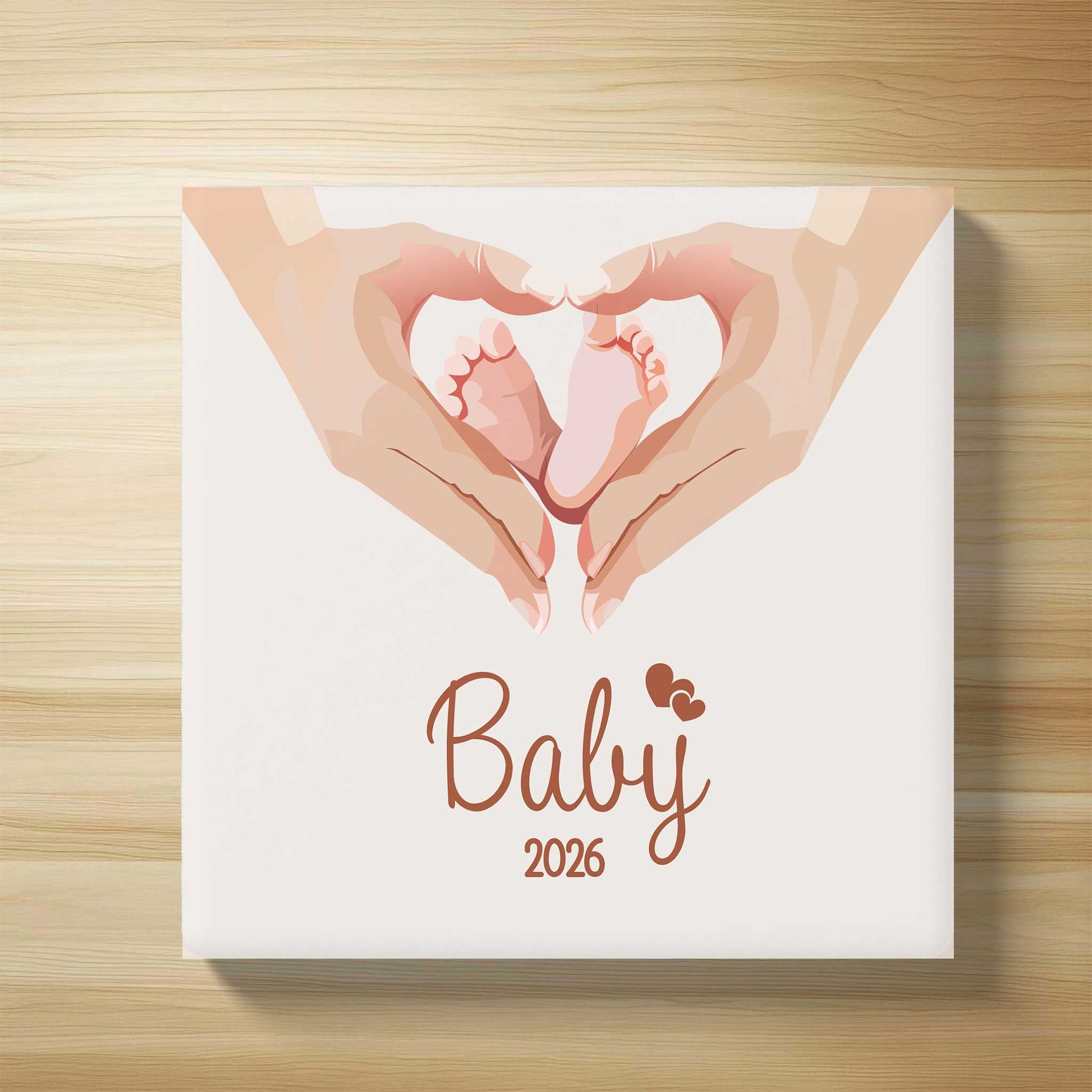 Bovenaanzicht van gepersonaliseerd babytegeltje met illustratie van babyvoetjes in hartvorm en de tekst Baby 2026 op houten ondergrond