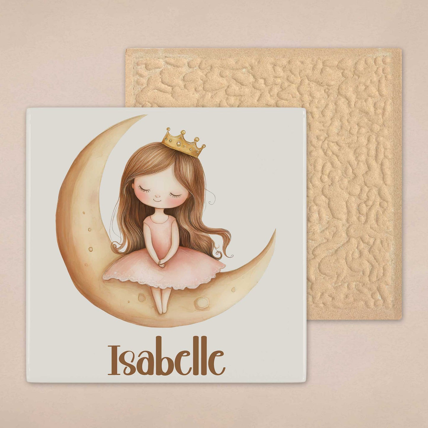 Keramisch tegeltje met een prinses op een gouden maan en de naam Isabelle, waarbij ook de achterzijde van het tegeltje zichtbaar is.