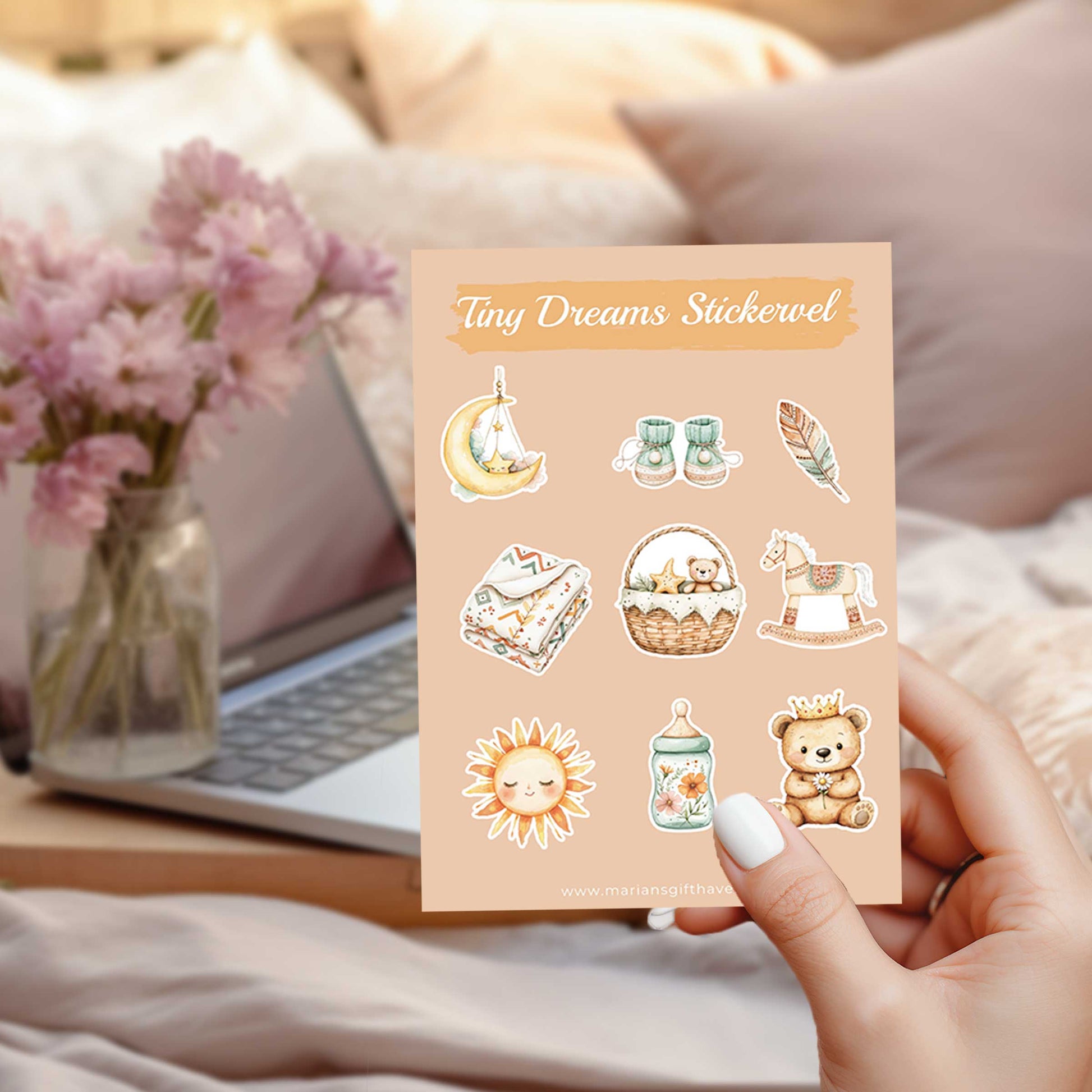 Tiny Dreams stickervel A6 met illustraties van een maan, babyschoentjes, veertje, babydekentje, mandje met knuffeltje, hobbelpaard, zonnetje, bloemenflesje en teddybeer, vastgehouden voor een laptop en roze bloemen.