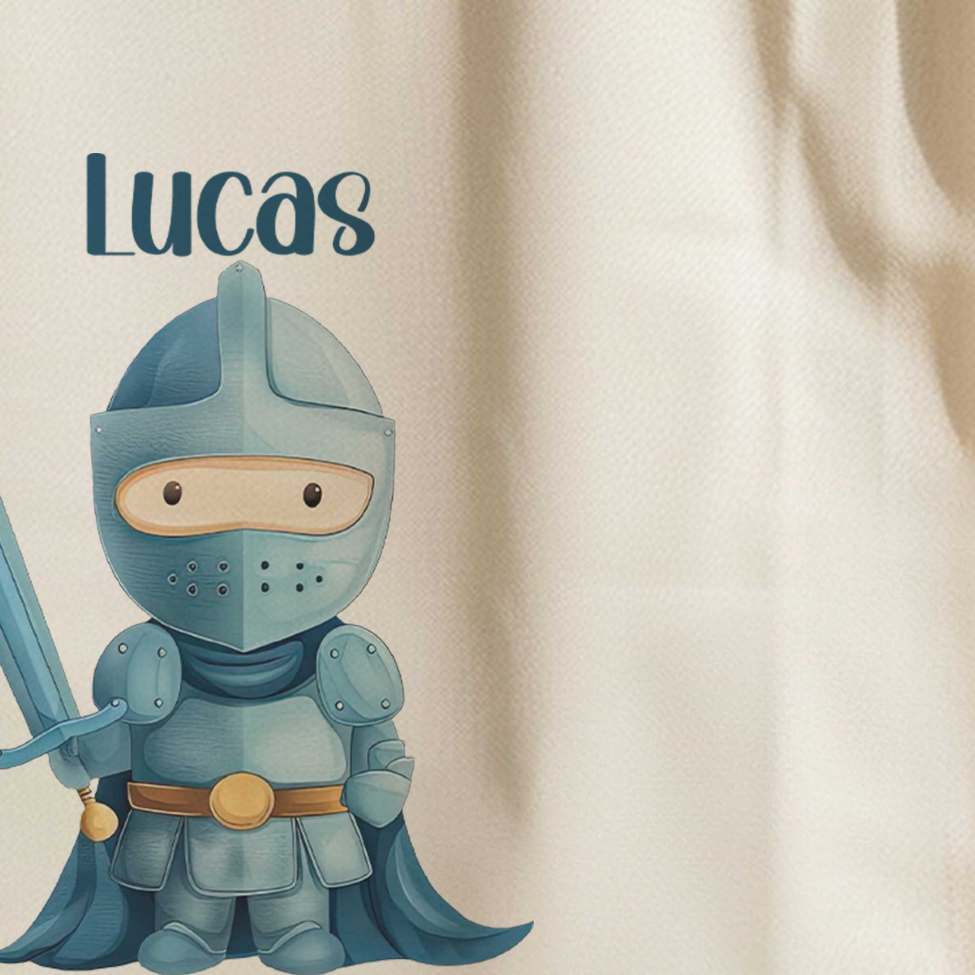 Close-up van de naam Lucas en de illustratie van een blauwe ridder met een zwaard op een witte totebag.