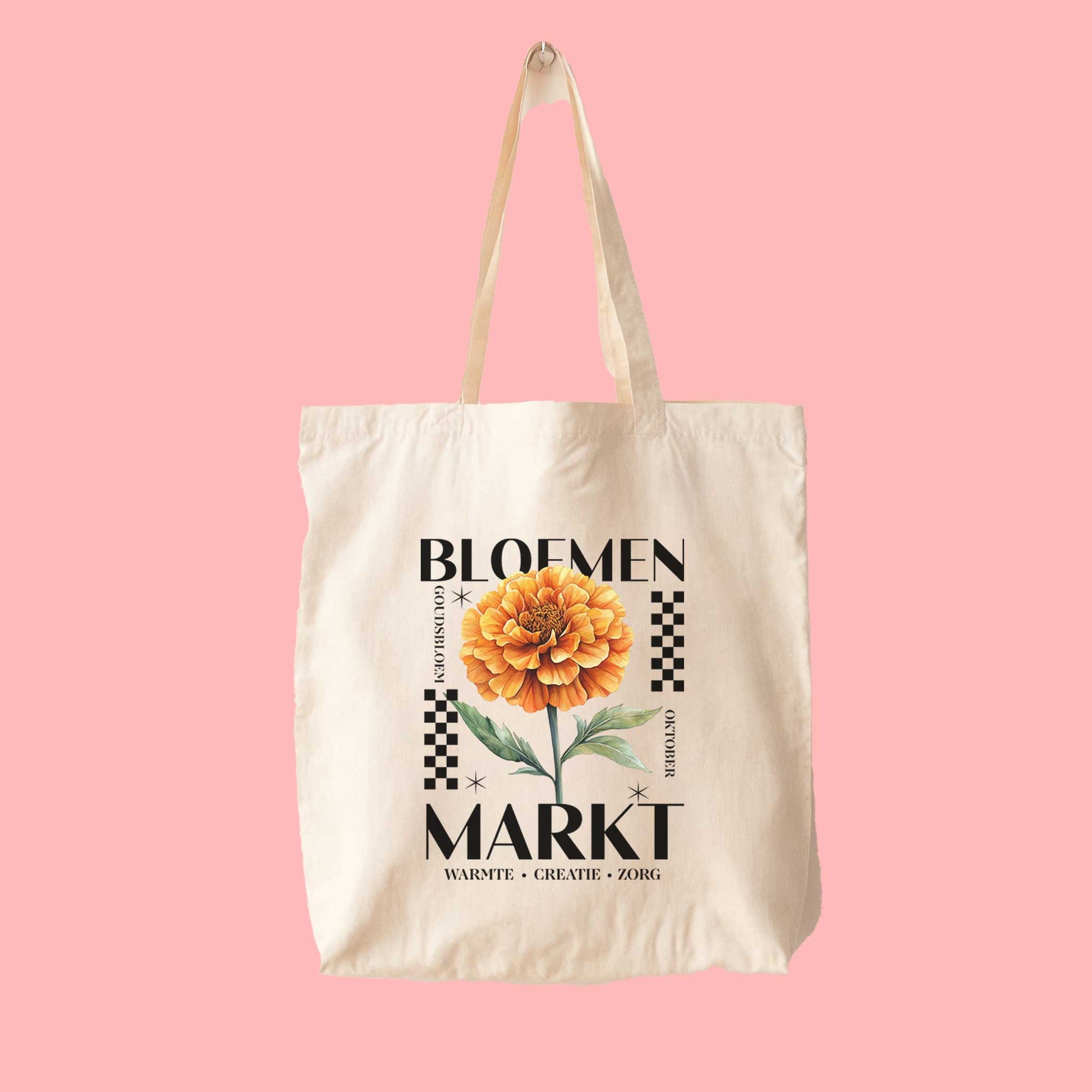 totebag met  de tekst bloemenmarkt en een illustratie van een geboortebloem van de maand oktober, een Goudsbloem. Met onderaan de kernwoorden van deze maand : warmte, creatie, zorg.