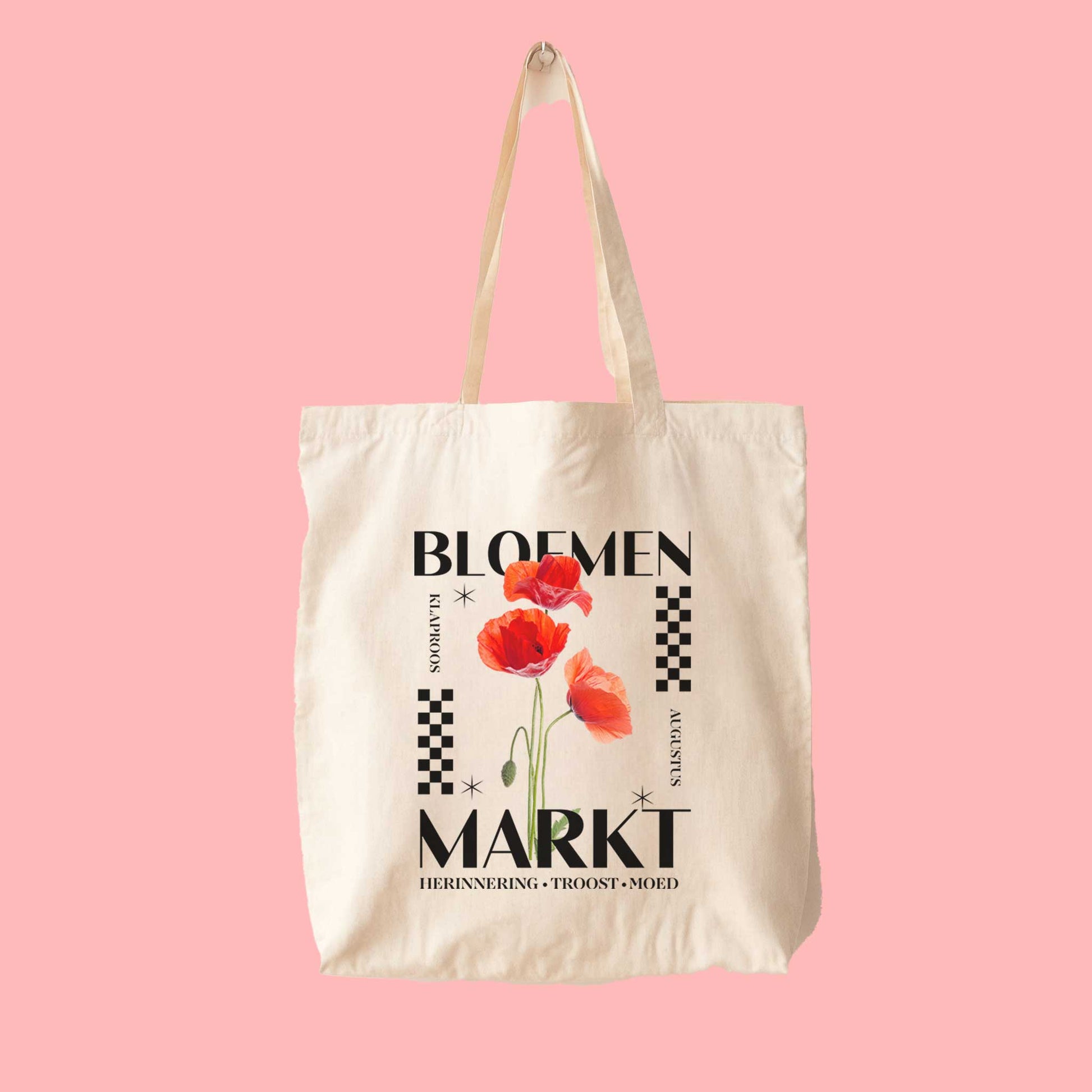 totebag met  de tekst bloemenmarkt en een illustratie van een geboortebloem van de maand augustus klaprozen. Met onderaan de kernwoorden van deze maand : herinnering, troost, moed